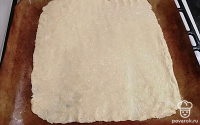 Тесто получается тугим и липким, поэтому распределяем тесто мокрыми руками по пергаменту или коврику. 