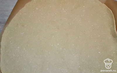 Высыпать муку, чтобы тесто не прилипало, и раскатать на пергаментном листе.