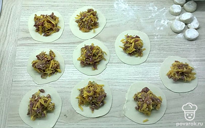 Отдохнувшее тесто раскатать тонко. Выложить начинку на каждый кружочек теста. 