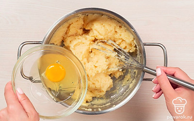 Взбейте яйца и замесите тесто. Куриные яйца разбейте в глубокую емкость и взбейте до однородности. Добавьте и активно вмешайте в теплое тесто примерно четверть взбитых яиц. Каждую следующую четверть взбитых яиц добавляйте только после того, как предыдущая часть полностью соединится с тестом. Таким образом введите в тесто всю яичную смесь. Заварное тесто должно получиться не слишком жидким и не слишком густым, и при этом однородным, гладким и вязким по консистенции.