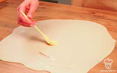 Раскатайте тесто. Посыпать стол мукой не нужно – тесто станет не таким эластичным и нежным. Вместо муки смажьте стол оставшимся подсолнечным маслом. Раскатайте во всех направлениях от середины к краям, смажьте сверху маслом, переверните и раскатайте с другой стороны — и так до тех пор, пока тесто не станет просвечивать.