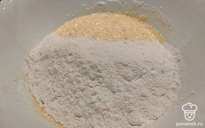 Всыпьте соду. Постепенно добавляя муку, перемешивайте. 