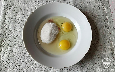 В глубокую посуду разбейте 2 яйца, добавьте 5 столовых ложек сахара. Взбейте венчиком яйца с сахаром.