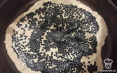 Один пласт теста выложите на противень, смажьте майонезом и выложите равномерным слоем черную имитированную икру.