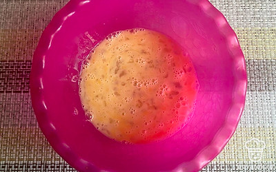 В миску разбейте куриные яйца и тщательно перемешайте венчиком.