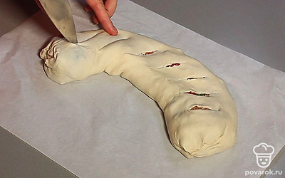 Переверните швом вниз. Ножом сделайте надрезы. Поставьте заготовку в духовку. Запекайте 30 минут до золотистого цвета.