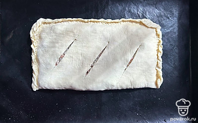 Противень застелите ковриком для выпечки. Выложите пирог. Сделайте три надреза.