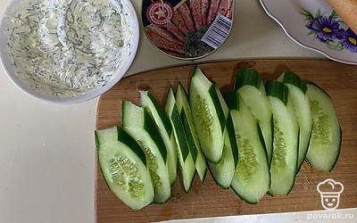 Нарежьте багет и огурец.