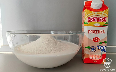 Ряженку комнатной температуры влейте в миску. Манную крупу всыпьте в ряженку и перемешайте. Оставьте смесь на 30 минут на столе.