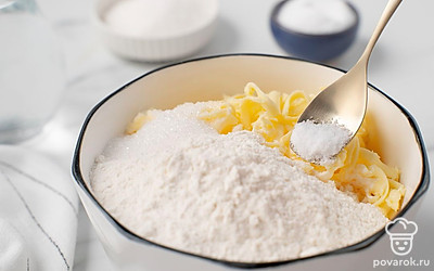 Достаньте масло и натрите его в миску. Всыпьте к нему муку. Добавьте соль и 1 ст.л. сахара. Влейте воду и замесите тесто. Когда масса станет однородной, скатайте тесто в шар, накройте пленкой и оставьте в холодильнике на 40 минут.