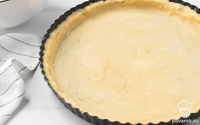 Разогрейте духовку до 180°C. Смажьте форму для выпечки небольшим количеством масла. Разделите тесто пополам. Раскатайте на припыленном мукой столе. Одну часть теста уложите в форму и сделайте бортики.