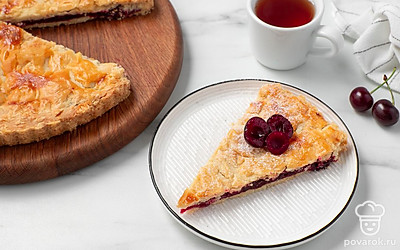 Посыпьте сахарной пудрой и украсьте вишней. Пирог получается очень вкусным как в горячем, так и в холодном виде. Но перед подачей на стол слегка остудите его, чтобы не обжечься горячей начинкой.