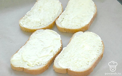 Ломтики батона или хлеба смажьте майонезом и выложите на противень. 