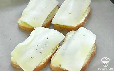 Накройте шпроты ломтиками твердого сыра.