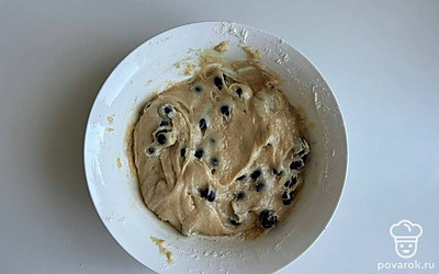 Ягоды смешайте с мукой, всыпьте в тесто и перемешайте.