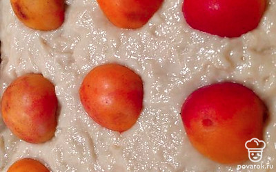 Выложить тесто в форму. Сверху выложите половинки абрикосов. Отправьте в разогретую духовку на 30 минут при 180 градусах.