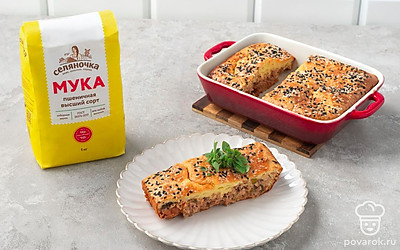 Разрежьте готовый пирог на порции, посыпьте кунжутом и подайте к столу, дополнив свежим базиликом.