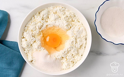 Смешайте в миске творог, 1 куриное яйцо и 50 г сахара, подготовленные для начинки.