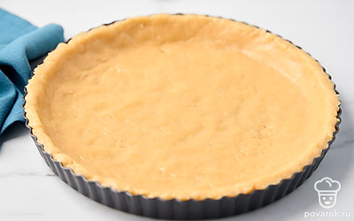 Достаньте тесто из холодильника, раскатайте его в тонкий пласт и выложите в форму для запекания, формируя бортики.