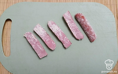 Обваляйте сосиски со всех сторон в муке.