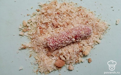 Обваляйте сосиски в панировочных сухарях. 