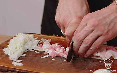 Нарежьте бекон тонкой соломкой, измельчите лук и чеснок. Налейте масло в сковороду, выложите бекон, лук и чеснок. Слегка обжарьте на среднем огне до золотистой корочки бекона. 