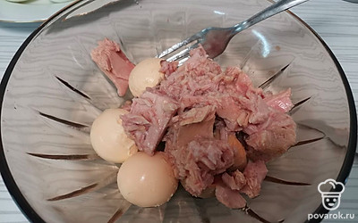 К желтку добавьте тунец и хорошо разомните вилкой. 