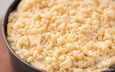 Соедините в миске 0,5 ст.л. охлажденного масла, 2 ст.л. муки и оставшийся сахар. Разотрите ложкой до крошки. Достаньте пирог из духовки, посыпьте его получившейся крошкой. Увеличьте нагрев духовки до 180°C и выпекайте пирог еще около 30 минут. 