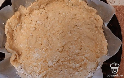 Форму для запекания застелите бумагой. Выложите тесто, мокрой ложкой сделайте бортики.