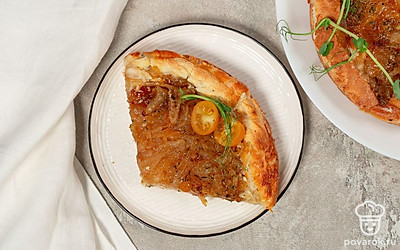 Украсьте тарт с луком дольками помидоров черри.