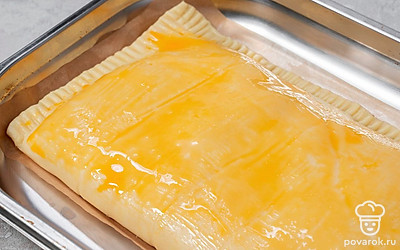 Разогрейте духовку до 180°C. Переложите пирог вместе с пергаментом на противень. Отправьте выпекаться в духовку на 50 минут.