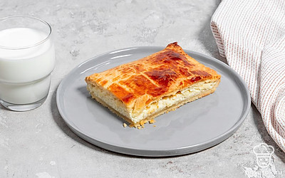 Подайте кусочек теплого сырного пирога со стаканом молока.