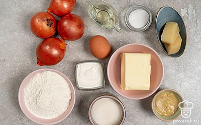 Помойте и очистите лук. Ополосните и вытрите яйцо. Просейте муку через мелкое сито. Подготовьте миску, глубокую сковороду, терку, круглую форму для пирога. Заранее смажьте форму 1 ч.л. сливочного масла. Разогрейте духовку до 200°C. 