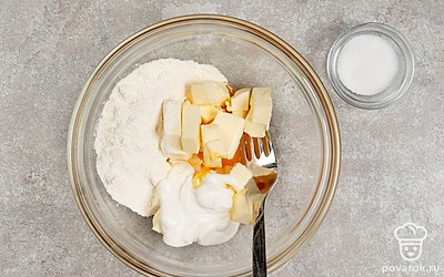 Всыпьте к маслу с желтком муку и половину соли, добавьте сметану. Разотрите содержимое миски в немного рассыпчатое мягкое песочное тесто. 