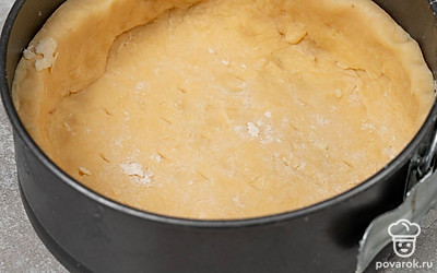 Слепите из теста круглую лепешку. Выложите ее в форму и распределите по ней, формируя бортики. Проколите дно в нескольких местах вилкой и поставьте в морозилку на 10-15 минут.