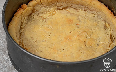 Пока лук томится на плите, достаньте форму с тестом из морозилки и поставьте в духовку на 20 минут.