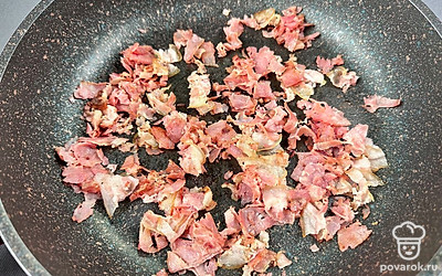 Бекон нарезаем крупной соломкой и обжариваем на сухой сковороде.