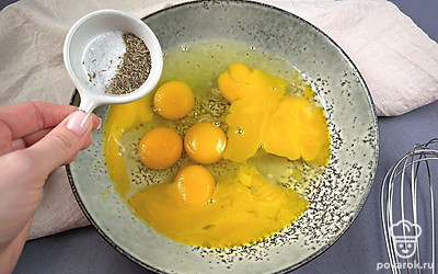 Затем в миску разбиваем яйца, добавляем соль, приправляем сухими травами и взбиваем до однородности.