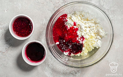 Отделите куриный белок от желтка. В миске смешайте творог с белком, вишневым и малиновым вареньем.