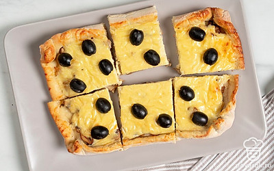 Украсьте пирог с грибами дольками маслин. 