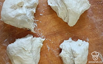 Достать тесто, сформировать из него шар, разделить его на четыре части.