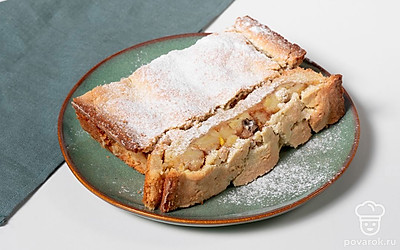 Готовому пирогу дайте остыть, нарежьте на порционные куски и посыпьте сахарной пудрой.