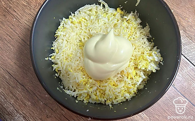 Яйца, сыр и чеснок натрите на мелкой терке. Заправьте майонезом.
