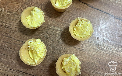 Заполните тарталетки начинкой, оставив небольшое углубление сбоку.