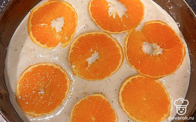Переложить тесто на противень или в форму. Разложить сверху апельсиновые кружки. Выпекать в духовке 25 минут.