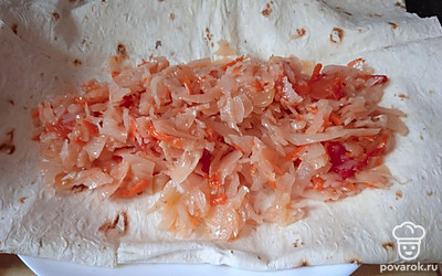 Лаваш сверните вдвое. Положите сверху тушеную капусту.