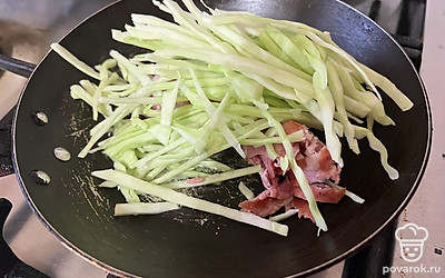 В раскаленное масло поместите колбасу, капусту, перец и соль. 