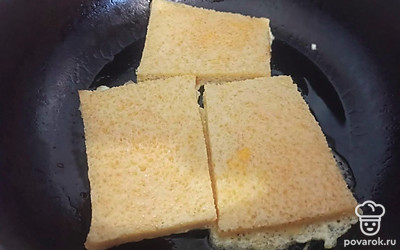 Выложите ломтики хлеба на горячую сковороду с подсолнечным маслом. Обжаривайте с одной стороны в течение 5 минут.