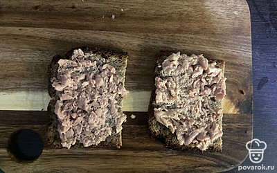Тост из цельнозернового хлеба разрежьте на две части. Обе части равномерно смажьте печенью трески, придавливая ее вилкой.