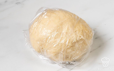 Переложите тесто в пищевую пленку или целлофановый пакет и уберите в холодильник на то время, пока готовите начинку. 